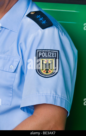 German policeman, epaulette of a police seargent, below it emblem of the Federal police, on the sleeve of a blue shirt, in fron Stock Photo