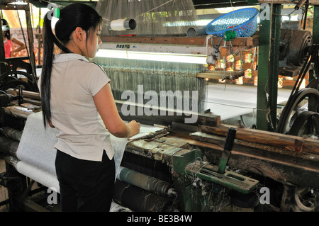 Woman working on a loom in a silk factory, Dalat, Central Highlands, Vietnam, Asia Stock Photo