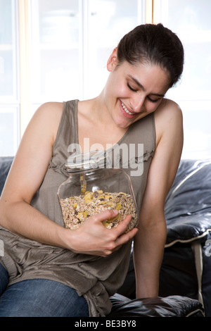 Beaming girl, looking at muesli jar Stock Photo
