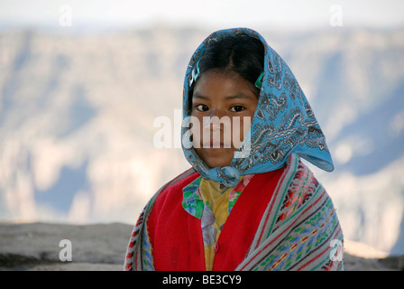 Young Tarahumara Indian girl sitting on cliff of Copper Canyon, Mexico Stock Photo