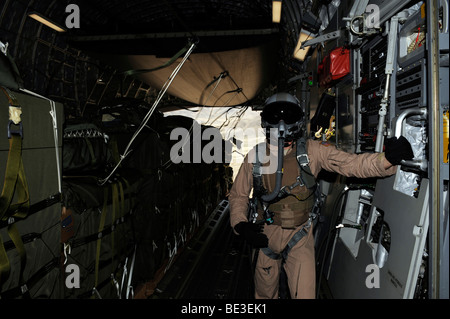 Container Delivery System bundles exit a C-17 Globemaster during an airdrop mission. Stock Photo