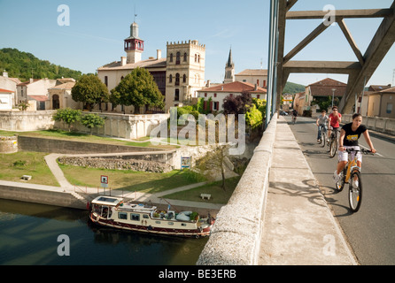 Cyclists crossing the bridge over the river Lot at Castelmoron, Lot-et-Garonne, Aquitaine, France Stock Photo