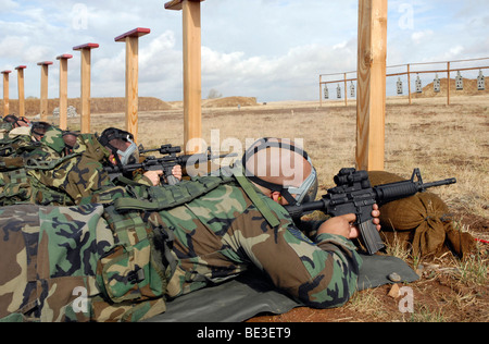 Soldiers sight M-4 rifles down range while wearing MCU-2 protective gas masks. Stock Photo
