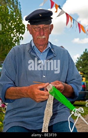 A fisherman mending fishing nets Stock Photo