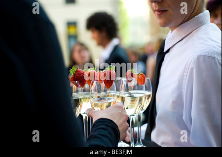 Guest taking a glass of sparkling wine from a tray Stock Photo