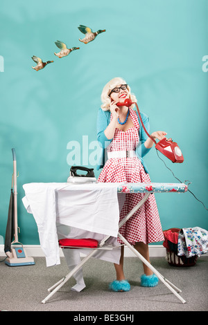 Retro image of 1960s housewife ironing Stock Photo