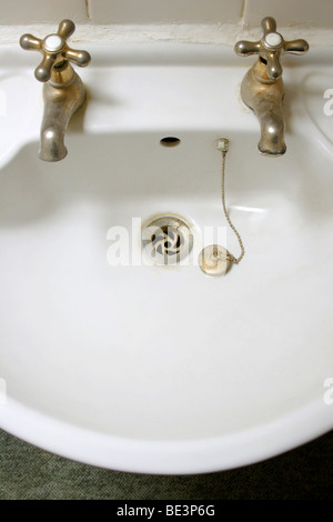 Empty bathroom sink with taps and plug Stock Photo