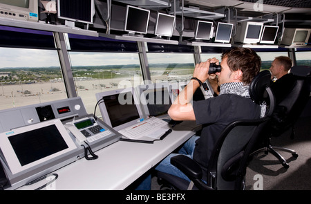 Two air-traffic controllers in 78 m high main tower of Munich Airport looking on to the apron West and Terminal 1, Bavaria, Ger Stock Photo