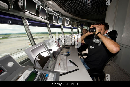 Two air-traffic controllers in 78 m high main tower of Munich Airport looking on to the apron West and Terminal 1, Bavaria, Ger Stock Photo