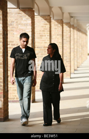 male and female walking together in conversation Stock Photo