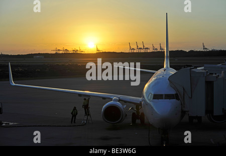 Qantas Airlines Boeing 717 refueling at sunrise, Brisbane International Airport, cranes in the rear, harbour, Brisbane, Queensl Stock Photo