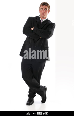 Young businessman leaning over a wall isolated on a white background Stock Photo