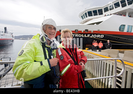 Older couple wearing exposure suit while preparing to go out on small rubber boat to view birds along coastal Norway. Stock Photo