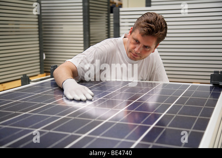 Solon SE: production of solar panels. Worker controlling the quality of a finished panel, BERLIN, GERMANY