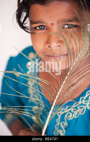 Indian girl holding a peacock feather. India Stock Photo