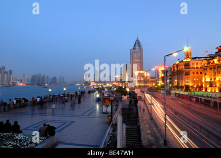 The illuminted Bund at night, the boulevard in Shanghai on the Huangpu River with pedestrians and car traffic, Shanghai, China, Stock Photo