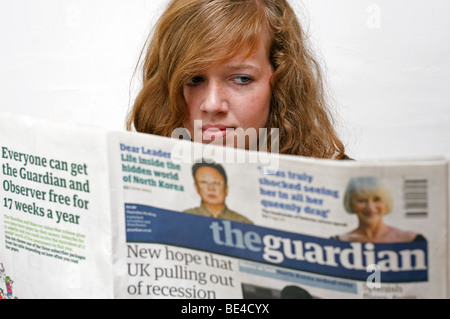 Teenager reading The Guardian newspaper. Stock Photo