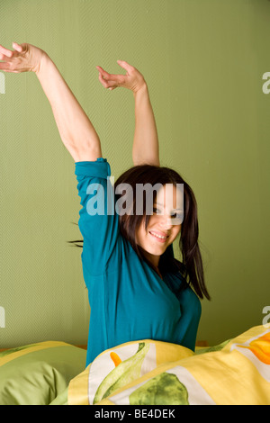 Young woman in bed, stretching Stock Photo