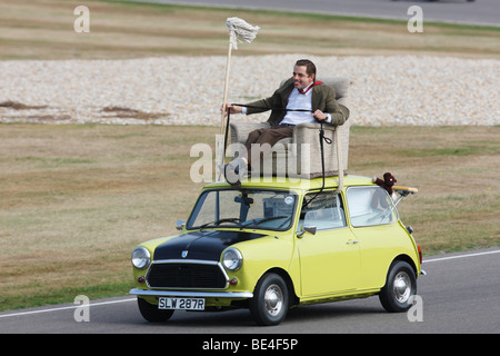 Mr Bean AKA Rowan Atkinson driving a mini from a roof armchair Stock Photo