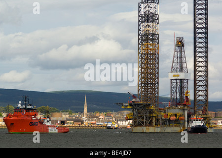 A jackup oil drilling rig, the Ensco 80, being towed up the Cromarty Firth, passing the town of Invergordon. Stock Photo