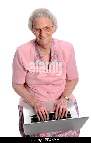 Portrait of elderly woman typing on laptop over white background Stock Photo
