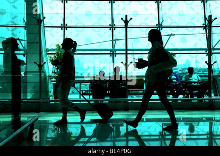 People in silhouette walking to gate at Dubai Airport UAE Stock Photo