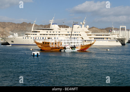 Old dhow and Sultan Qaboos royal yacht, Mutrah harbour, Muscat, Sultanate of Oman, Arabia, Middle East Stock Photo