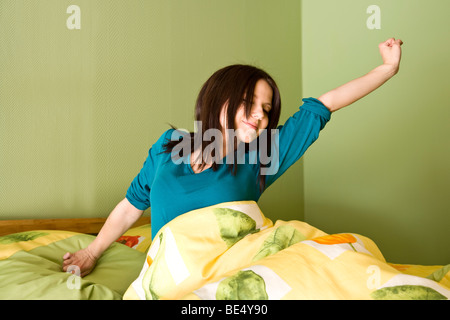 Young woman in bed, stretching Stock Photo