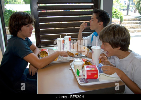 French teenage boys eat at a McDonalds fast food restaurant in Southern France. Stock Photo