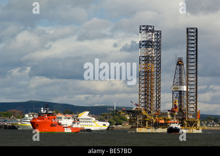 A jackup oil drilling rig, the Ensco 80, being towed up the Cromarty Firth, passing a cruise ship at Invergordon Stock Photo