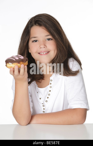 Cute Caucasian girl eating a donut on a white background Stock Photo