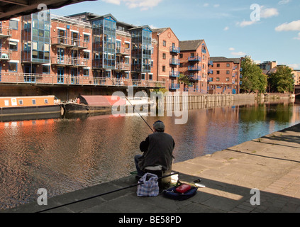 Fisherman and River Aire in Leeds UK with apartments and longboats Stock Photo