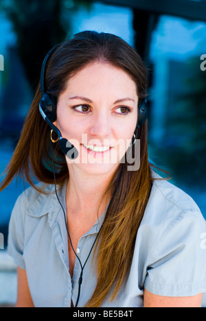 Smiling support woman talking with customers with headset phone in blue background Stock Photo