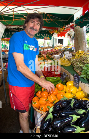 French vendor stocking produce at an outdoor market in Sanary sur Mer, Southern France. Stock Photo