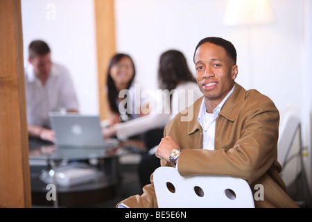 Portrait of African American man in foreground with co-workers in background Stock Photo