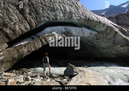 Visitor looks at the glacier mouth of the Langgletscher glacier,  Loetschental, Valais, Switzerland Stock Photo