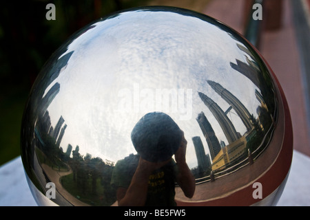 Photographer reflected in a mirror sphere taking picture to the Petronas Tower. Kuala Lumpur. Malaysia Stock Photo