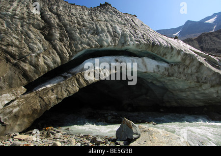 Melting ice arch of the glacier mouth of the Langgletscher glacier at the end of the ice front, Loetschental, Valais,Switzerland Stock Photo