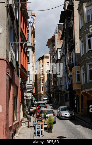 Typical street in Galatasarary, restaurant with two small tables on the street, woman serving a guest, Beyoglu, Istanbul, Turkey Stock Photo