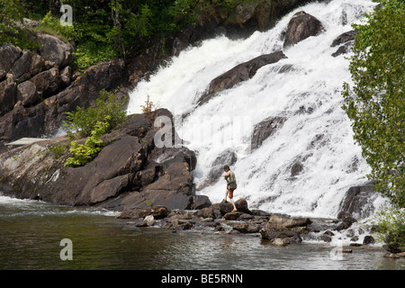 Fishing at the Falls. A young man, cigarette in mouth fishes at the bottom of the outflow from Lac Mercier Stock Photo