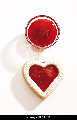 Heart-shaped short pastry jam biscuit, strawberry jam in a glass bowl Stock Photo