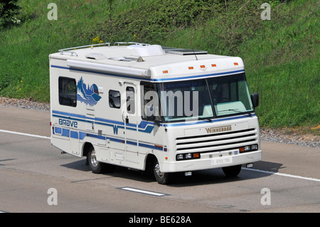 White American Winnebago Brave RV recreational vehicle motorhome camper van driving along UK England motorway road obscured number plate Stock Photo