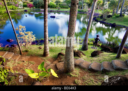 Pond and garden sculpture at Na Aina Kai Botanical Gardens. Kauai, Hawaii Stock Photo