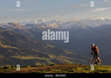 Mountainbiker at Hohe Salve mountain, the Grossvenediger mountain in the back, Tyrol, Austria, Europe Stock Photo