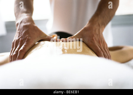 Hands of massage therapist massaging woman's back Stock Photo