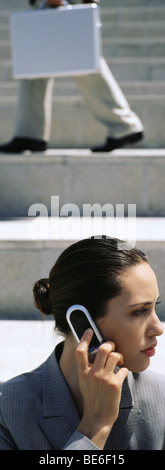 Businesswoman using cell phone, looking away Stock Photo