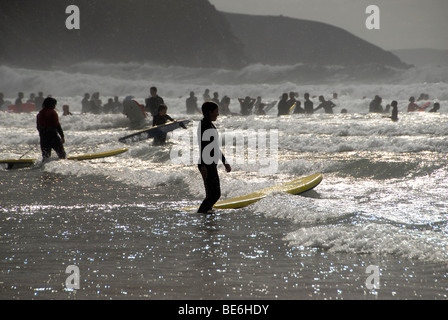 Surfers and body boarders in surf on Perranporth beach Cornwall UK Stock Photo