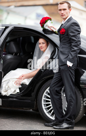 Young wedding couple at the luxury car. Stock Photo