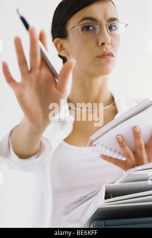 Woman with notepad, gesturing not to interrupt work Stock Photo
