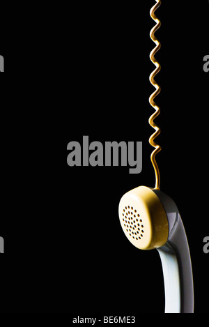 Telephone receiver hanging by cord Stock Photo